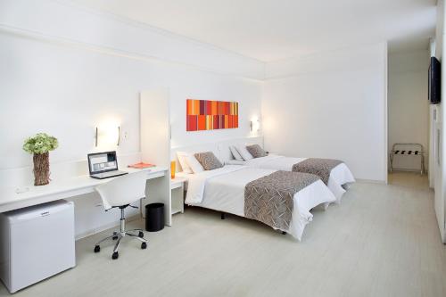 um quarto branco com 2 camas e uma secretária em Boulevard Plaza em Belo Horizonte