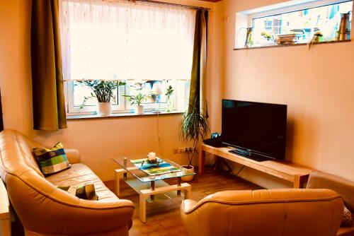 a living room with two chairs and a flat screen tv at FerienTurm in Niederstetten