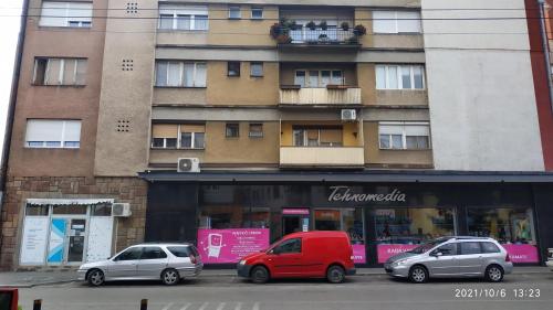 three cars parked in front of a building at Apartman Rada in Pirot