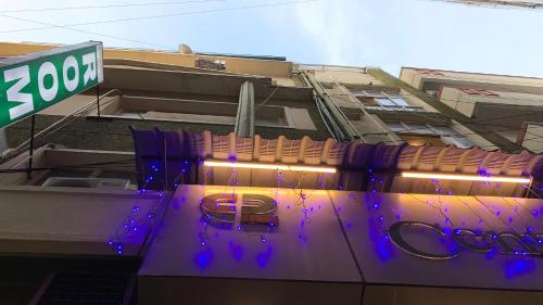 a building with a sign and purple lights on it at Half Moon Palace Chennai in Chennai