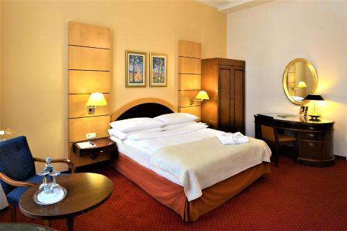 a hotel room with a large bed and a mirror at Hotel am Kochbrunnen in Wiesbaden