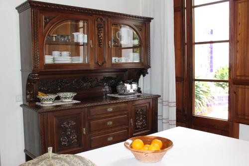 a large wooden cabinet with a bowl of fruit on a table at Sant Jaume in Alcudia