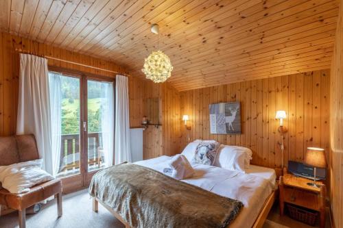 a bedroom with a bed and a chandelier at Chalet ChouChou in Morgins