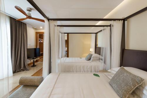 a bedroom with two beds and a living room at Il San Corrado di Noto in Noto
