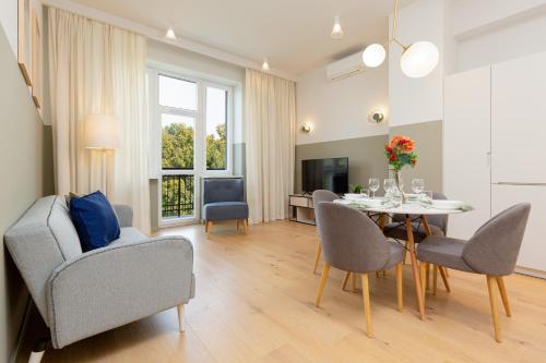 uma sala de estar com uma mesa de jantar e cadeiras em Apartments Warsaw Gagarina by Renters em Varsóvia