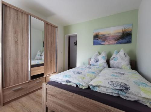 1 dormitorio con cama y espejo grande en Ferienwohnung Schwallmann, en Wilnsdorf