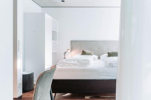 a bedroom with a bed with white sheets and pillows at Blackhome Innsbruck City South I contactless check-in in Innsbruck