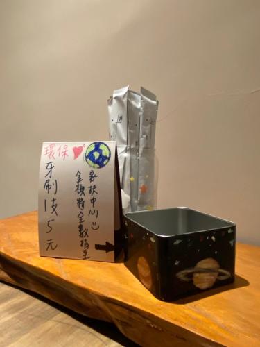 a wooden table with a black box and a paper at Enjoy Homestay in Tainan
