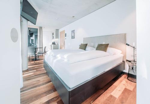 ein Schlafzimmer mit einem großen weißen Bett in einem Zimmer in der Unterkunft Blackhome Innsbruck City South I contactless check-in in Innsbruck