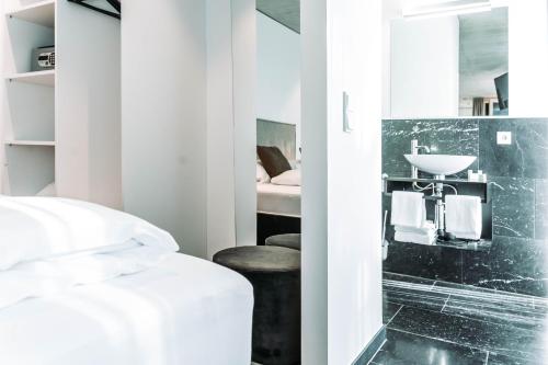 a bathroom with a bed and a sink and a mirror at Blackhome Innsbruck City South I contactless check-in in Innsbruck
