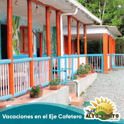 a building with orange and blue columns and potted plants at Hotel Campestre Alto Bonito del Quindío in El Cuzco