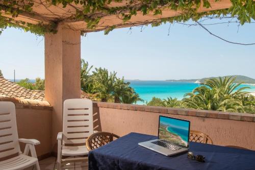 a laptop computer sitting on a table on a patio at Residence Fenicia in Villasimius