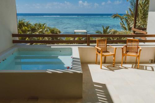 a patio area with chairs, tables, and a pool at Jashita Hotel in Tulum