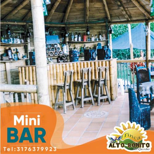 a restaurant with a bar with stools and tables at Hotel Campestre Alto Bonito del Quindío in El Cuzco