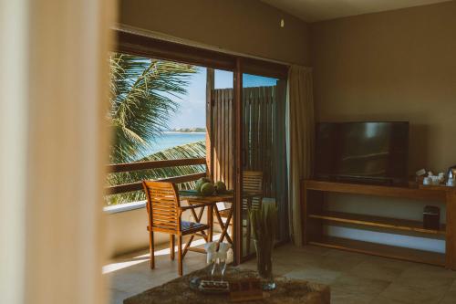 Sala de estar con mesa y vistas al océano en Jashita Hotel, en Tulum
