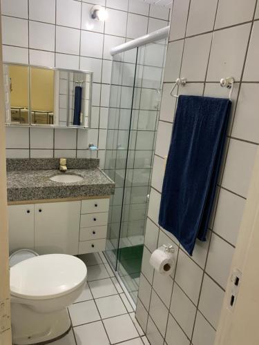 a bathroom with a toilet and a blue towel at Flat Crystal Park Porto das Dunas- Cristal park in Aquiraz