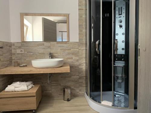 Un baño con lavabo y ducha de cristal. en Agriturismomillefiori, en Manciano