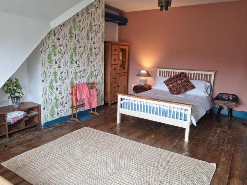 a bedroom with a white bed in a room with a wall at Beautiful space on top of Edwardian house in Hastings