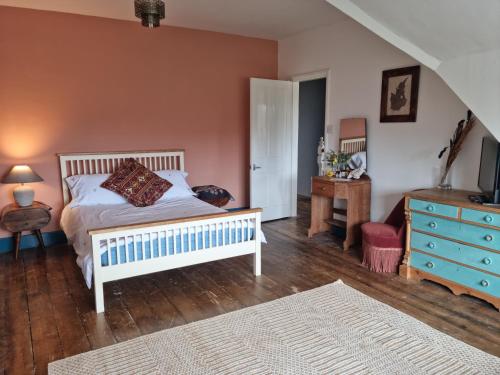 um quarto com uma cama branca e uma cómoda azul em Spacious top floor suite top of Edwardian house em Hastings