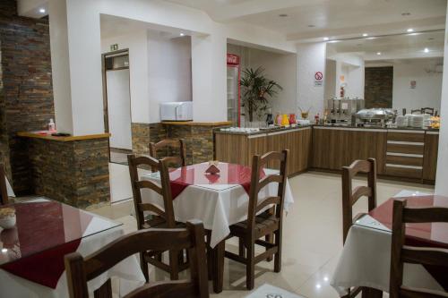 un restaurant avec une table et des chaises ainsi qu'une cuisine dans l'établissement Hotel Masseilot, à Santana do Livramento