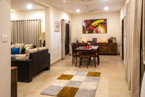 sala de estar y comedor con mesa y sillas en BluSalzz Villas - The Ambassador's Residence, Kochi - Kerala, en Kochi