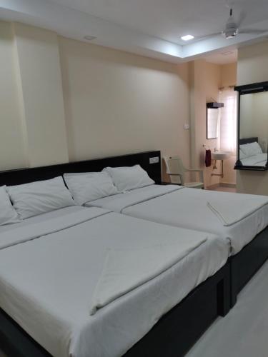 1 dormitorio con 1 cama blanca grande en una habitación en SRI VIGNESH RESIDENCY, en Chennai