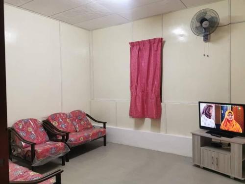 a waiting room with two chairs and a tv at Homestay Teduhan Gunung, Gopeng in Gopeng