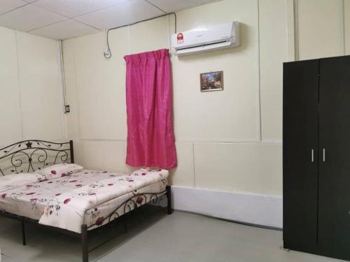 mały pokój z łóżkiem i różową zasłoną w obiekcie Homestay Teduhan Gunung, Gopeng w mieście Gopeng