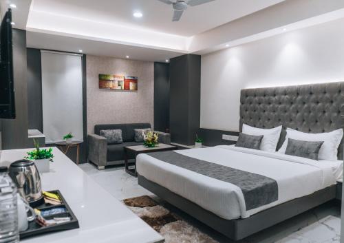 um quarto de hotel com uma cama e um sofá em Jardin Hotels em Indore