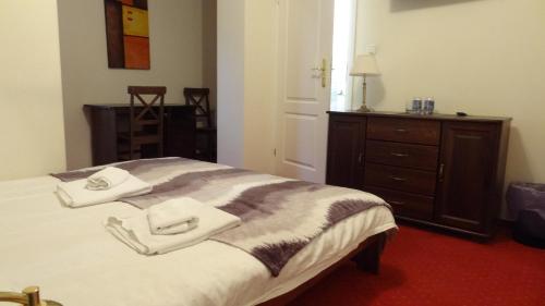 a bedroom with a bed with two towels on it at Dworek Szwajcaria in Zwardoń