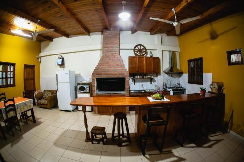cocina con mesa y chimenea de ladrillo en La Posada de Moncho en Puerto Iguazú