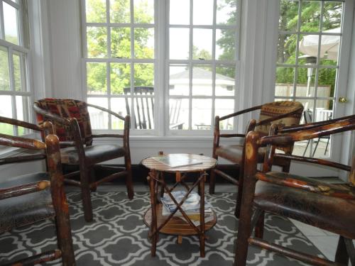 a room with chairs and a table and windows at The Bond 1786 Inn in Warrensburg