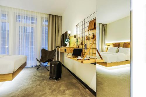 a hotel room with a bed and a desk with a laptop at poznańska19 in Nowy Tomyśl