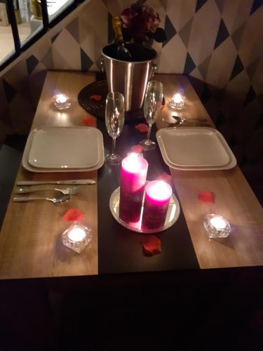 a wooden table with candles and wine glasses on it at escapade romantique 56 in Plouray