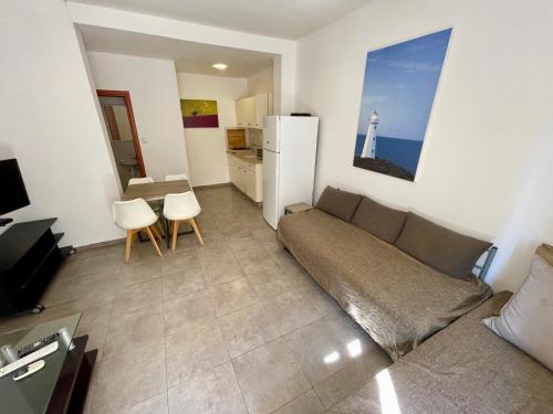 a living room with a couch and a kitchen with a lighthouse at Miraks HaRav Kuk in Tel Aviv