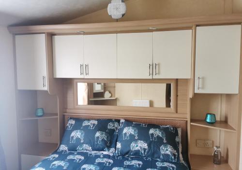 a bedroom with a bed with white cabinets at Tranquil 6 Berth Luxury Holiday Home in Chichester