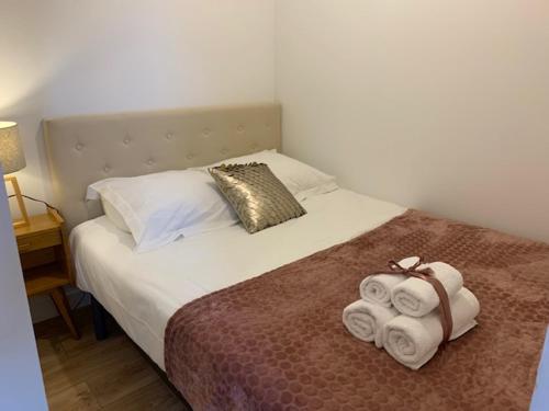 - une chambre avec un lit et des serviettes dans l'établissement Le RoseGarden Studio au pied de la Gare de Rennes, à Rennes