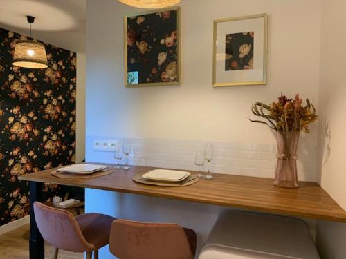 une table avec deux chaises et un vase de fleurs dans l'établissement Le RoseGarden Studio au pied de la Gare de Rennes, à Rennes