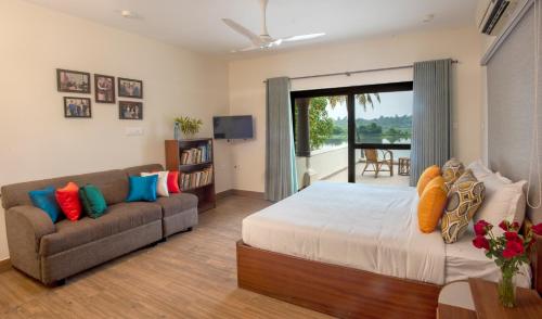 a living room with a bed and a couch at BluSalzz Villas - The Ambassador's Residence, Kochi - Kerala in Cochin