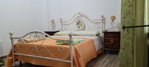 a bedroom with a bed with an orange blanket at FATTORIA ROVELLO in San Paolo di Civitate