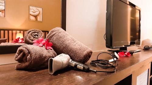 a desk with a television and a towel pile at Cuti de Gold Coast Morib in Banting