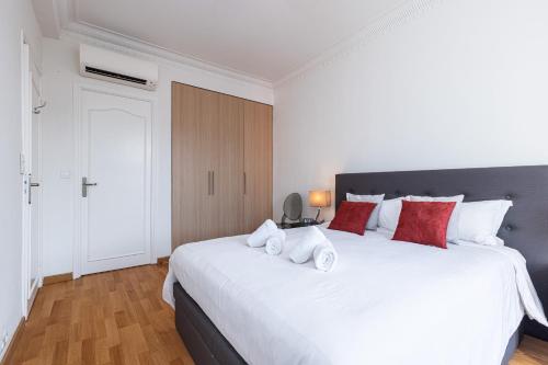 une chambre avec un grand lit blanc avec des oreillers rouges dans l'établissement Sea View Large 2 Bdr Promenade des Anglais, à Nice
