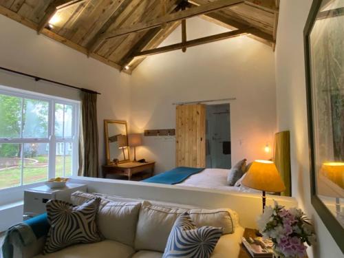 a bedroom with a large bed and a couch at Yellowwoods Farm - THE GOAT HOUSE in Curryʼs Post