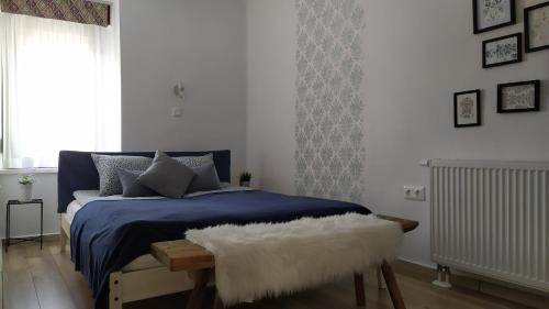 Un dormitorio con una cama azul y una ventana en Várvölgy Vendégház - teljes ház, kizárólagos használattal, en Veszprém