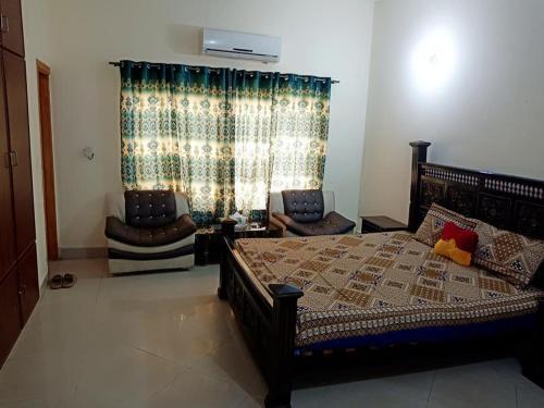 a bedroom with a large bed and a chair at Hotel 4 Seasons in Multan