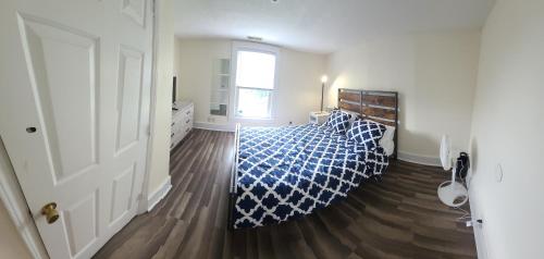 a bedroom with a blue and white bed and a window at The Dragon's Den 5 bedroom house 1 mile to Main St in Tazewell