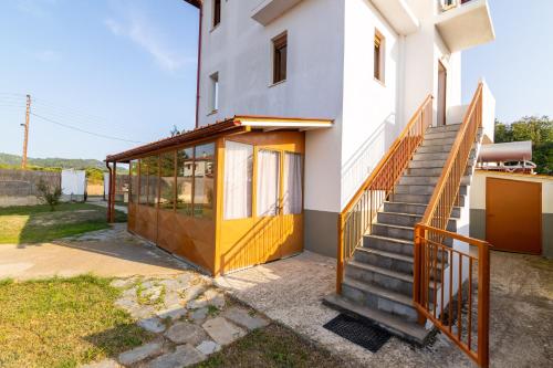 a building with a yellow door and a staircase at F & B Summer Collection - Kassandra - Fourka in Skála Foúrkas