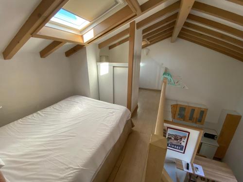 an attic bedroom with a bed and a skylight at Hôtel & Appart-hôtel Olatua in Bidart