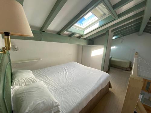 a bedroom with a white bed and a window at Hôtel & Appart-hôtel Olatua in Bidart