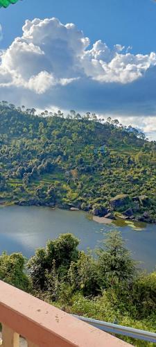 a view of a river with trees and a mountain at Ritu Raj Home Stay & Cafe in Malther